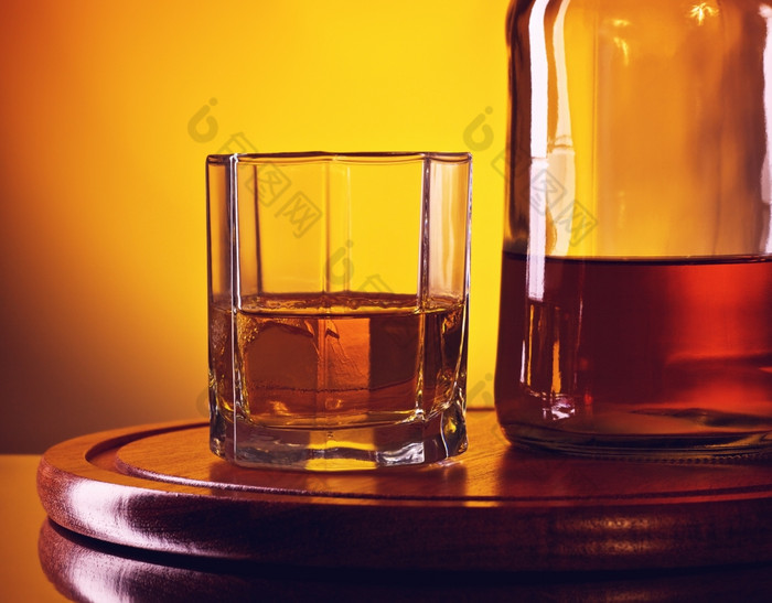 威士忌瓶和玻璃玻璃和瓶威士忌黄色的背景