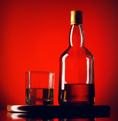 威士忌瓶和玻璃玻璃和瓶威士忌红色的背景