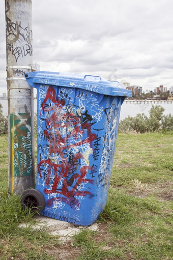 蓝色的垃圾箱与的城市的背景蓝色的垃圾箱