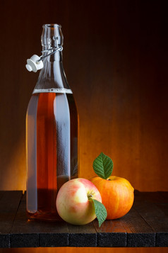 苹果苹果酒瓶与成熟的苹果乡村木表格静物