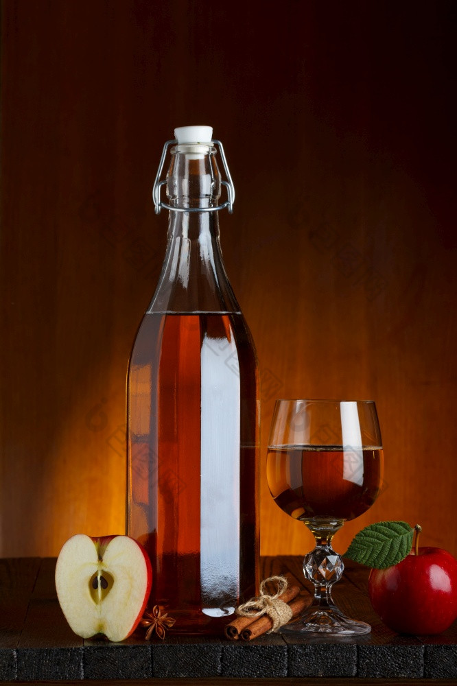 瓶和玻璃苹果苹果酒与切片苹果木表格与肉桂和茴香明星