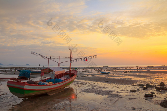 小木船与光灯泡为晚上鱿鱼钓鱼的海岸在低潮潮泰国