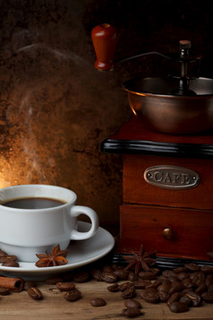 杯热咖啡与磨床和香料木表格仍然生活