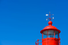 红色的灯塔屋顶圆顶灯笼房间与风叶片在清晰的蓝色的夏天天空背景与复制空间