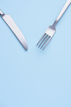 斯泰尔新清洁刀和叉蓝色的柔和的纸背景有创意的平躺与复制空间