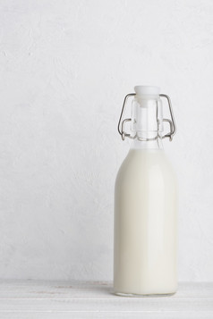 瓶牛奶与摇摆不定的前关闭白色木表格背景