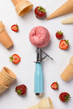 草莓冰奶油独家新闻勺子与晶片视锥细胞和浆果白色表格平铺