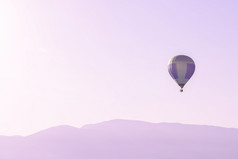 热空气气球的粉红色的天空以上软日出山轮廓与复制空间