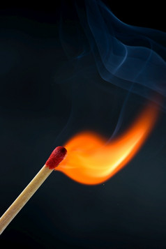 木匹配坚持与红色的头点燃和燃烧明亮的大火火焰与烟黑色的背景