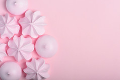 蛋白酥皮饼干甜蜜的脆皮扭曲的和下降蛋白酥皮粉红色的柔和的背景与Copy-Space