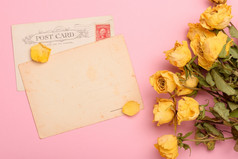 古董帖子卡片与干黄色的玫瑰花柔和的玫瑰背景前视图