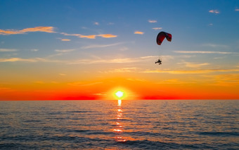 轮廓滑翔伞飞行在海日落日落海和滑翔伞