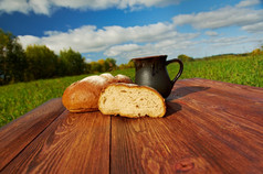 自制的面包而且杯子牛奶木tableBackground蓝色的skyOutdoor农家菜
