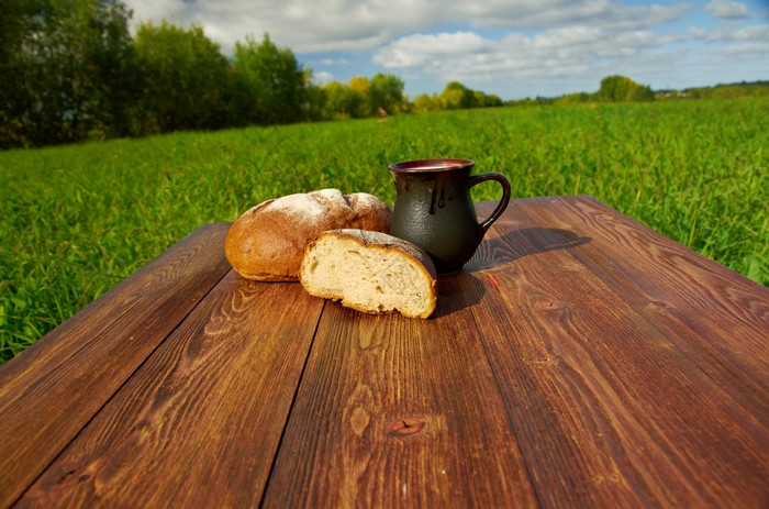 自制的面包而且杯子牛奶木tableBackground蓝色的skyOutdoor农家菜