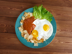 鸡蛋与chilaquiles墨西哥传统的早餐鸡蛋鸡蛋与玉米粉圆饼芯片超过与红色的酱汁