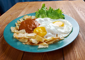 鸡蛋与chilaquiles墨西哥传统的早餐鸡蛋鸡蛋与玉米粉圆饼芯片超过与红色的酱汁