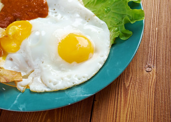 鸡蛋与chilaquiles墨西哥传统的早餐鸡蛋鸡蛋与玉米粉圆饼芯片超过与红色的酱汁