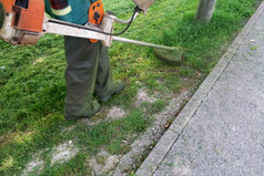 工人电动机割草机切割草城市公园