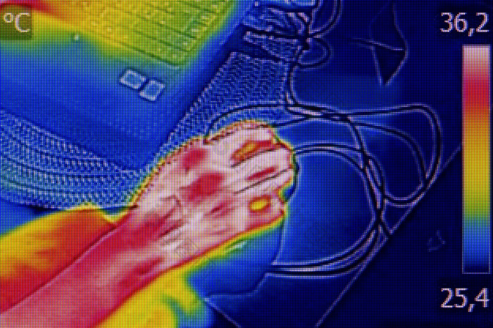 红外温度记录图像显示的热发射当女人使用笔记本