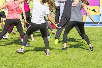 集团年轻的女孩锻炼健身与跳舞的城市公园