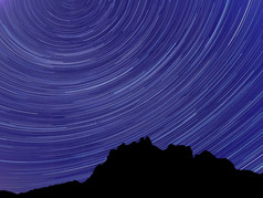 长曝光图像显示晚上天空明星小径在山