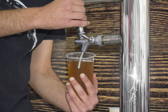 酒保填充塑料玻璃与光啤酒