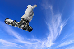 滑雪滑雪跳通过空气与蓝色的天空背景