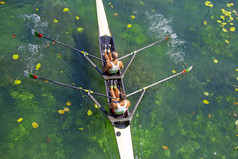 两个年轻的运动员划船团队绿松石绿色湖