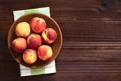 新鲜的成熟的桃子粘土板拍摄开销黑暗木与自然光新鲜的成熟的桃子