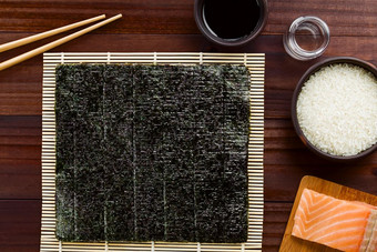 寿司成分紫菜海藻makisu竹子席为滚动筷子我是酱汁大米醋生寿司大米和新鲜的生大马哈鱼的一边拍摄开销寿司成分