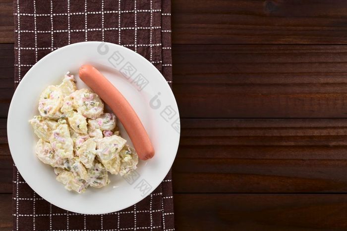 新鲜的自制的德国土豆沙拉土豆沙拉使土豆洋葱泡菜和蛋黄酱服务与香肠板拍摄与复制空间开销黑暗木土豆沙拉与香肠