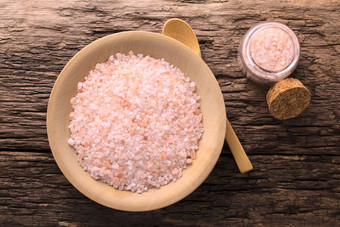 粗粉红色的喜玛拉雅盐木板木勺子和小玻璃瓶盐的一边拍摄开销粗粉红色的喜玛拉雅盐