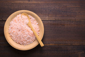 粗粉红色的喜玛拉雅盐木板与木勺子拍摄开销与复制空间的一边粗粉红色的喜玛拉雅盐