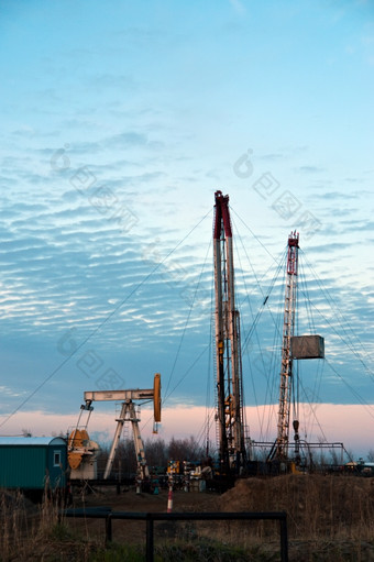 石油泵而且<strong>钻井钻井</strong>平台的日落天空背景俄罗斯西方西伯利亚