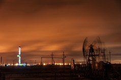石油泵杰克和钻井钻井平台的晚上天空背景长曝光