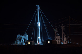 石油泵杰克和钻井钻井平台的晚上天空背景石油字段西方西伯利亚