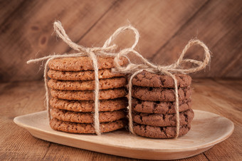 自制的绳全麦饼干与燕麦片亚麻和芝麻种子和传统的饼干与巧克力芯片黑暗乡村木表格健康的素食主义者食物概念