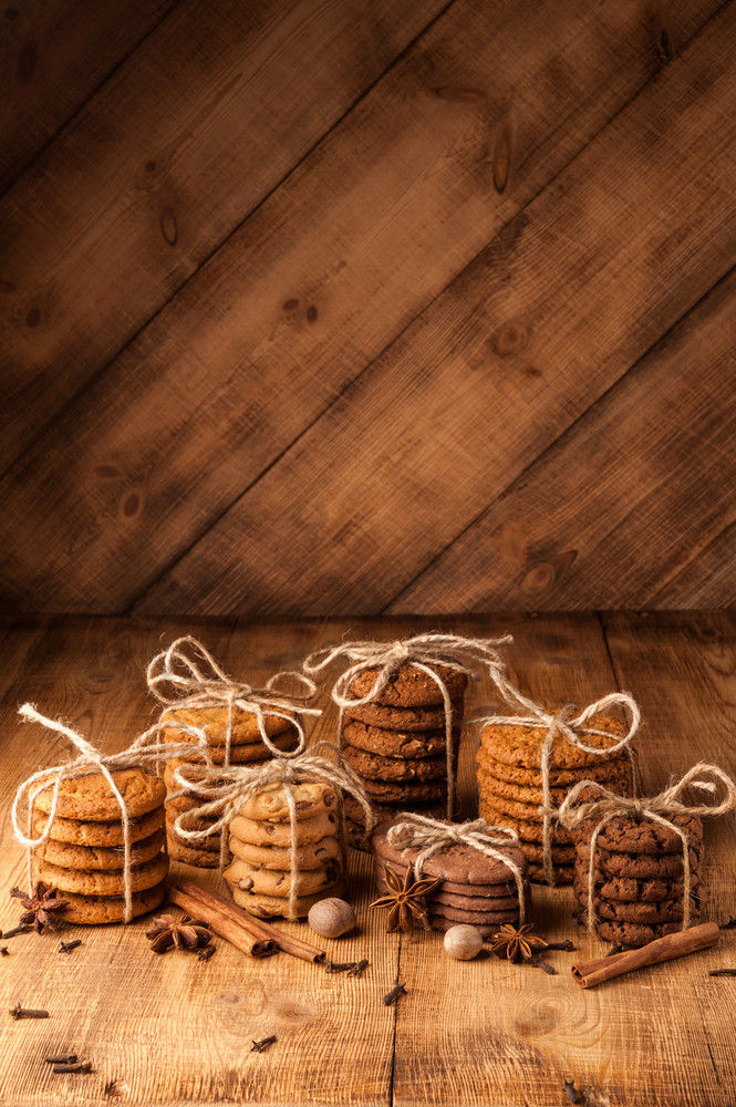 自制的绳全麦饼干与燕麦片亚麻和芝麻种子和传统的饼干与巧克力芯片黑暗乡村木表格和香料各种各样的酥饼燕麦饼干巧克力芯片饼干和香料黑暗乡村木表格