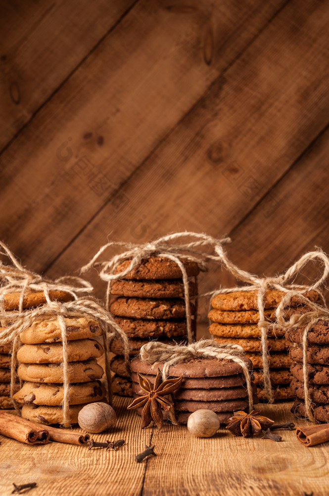 自制的绳全麦饼干与燕麦片亚麻和芝麻种子和传统的饼干与巧克力芯片黑暗乡村木表格和香料各种各样的酥饼燕麦饼干巧克力芯片饼干和香料黑暗乡村木表格