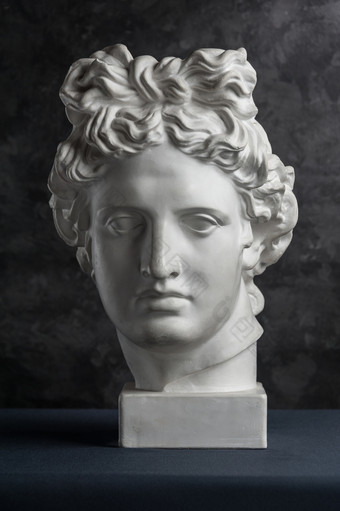 白色石膏复制古老的雕像阿波罗神太阳头为艺术家黑暗变形背景石膏雕塑男人。脸石膏复制古老的雕像阿波罗头黑暗变形背景石膏雕塑男人。脸