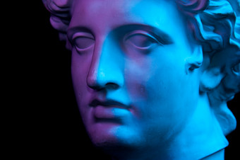 白色石膏复制古老的雕像阿波罗神太阳头为艺术家孤立的黑色的背景石膏<strong>雕塑</strong>男人。脸健美的蓝色的和紫色的石膏复制古老的雕像阿波罗头孤立的黑色的背景石膏<strong>雕塑</strong>男人。脸