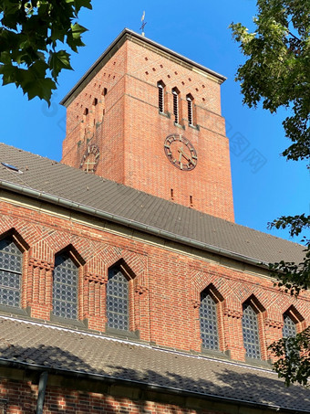 特写镜头图像的教区教堂科隆霍尔韦德对蓝色的天空和树树叶德国