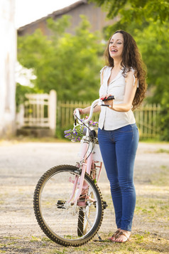 美丽的年轻的女人与她的自行车
