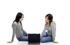 两个女年轻的学生工作与移动PC