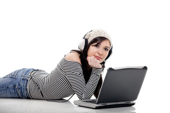年轻的女人工作与移动PC和听音乐的相同时间