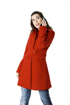美丽的年轻的女人与红色的外套持有手机