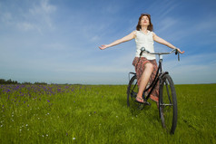 快乐年轻的女人放松在古董自行车