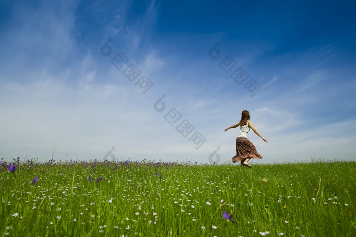 年轻的女人跳舞美丽的绿色草地