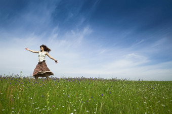 年轻的女人跳舞美丽的绿色草地