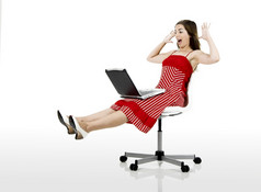 肖像快乐女人坐着椅子与移动PC孤立的白色